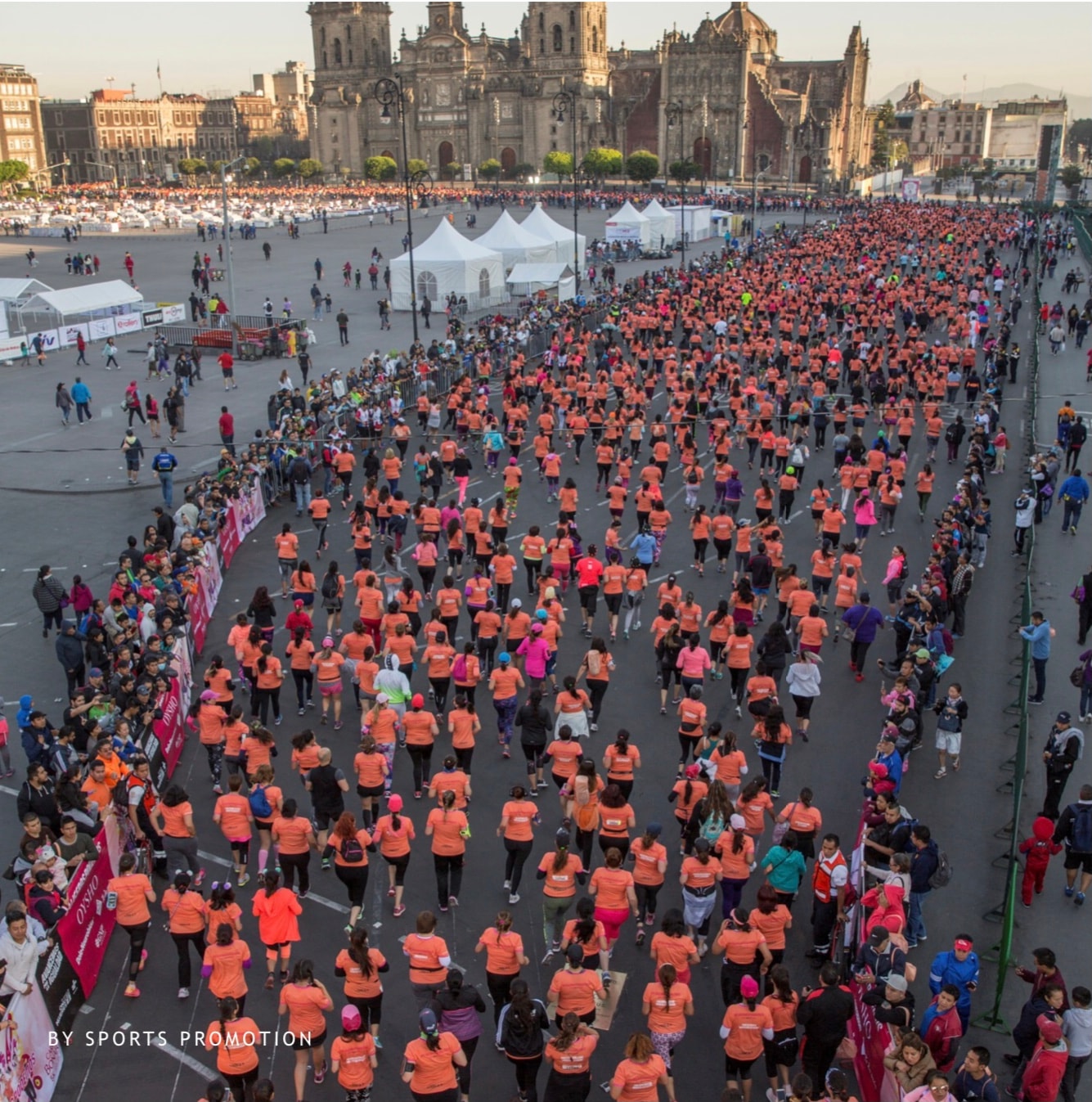 Miles de corredoras con playeras naranjas arrancando desde el Zócalo CDMX — vista aérea