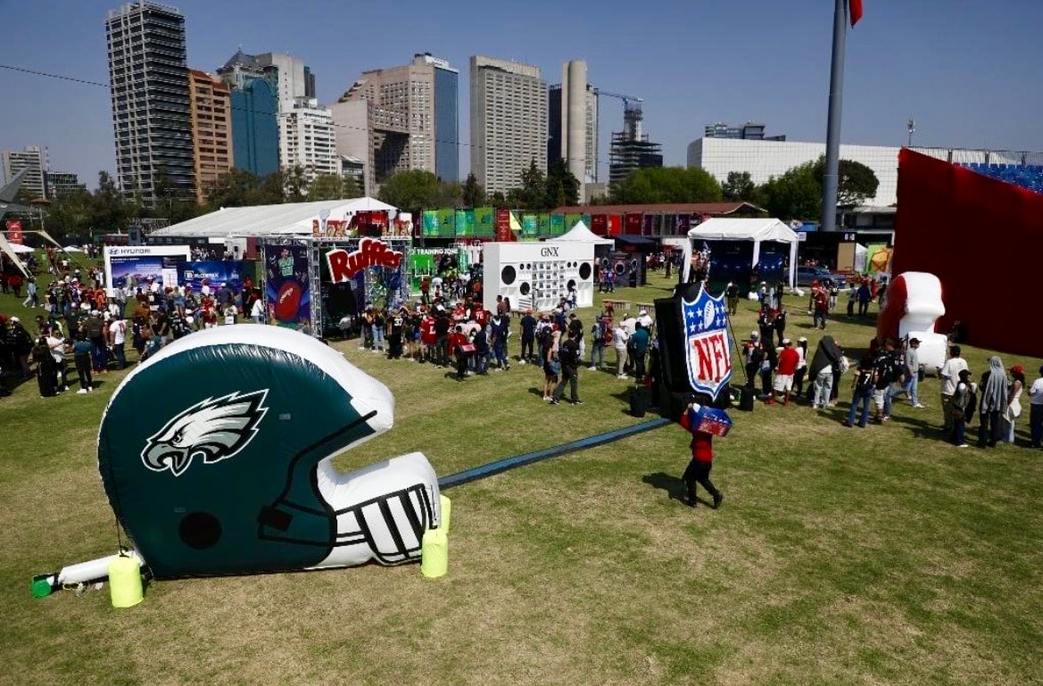 Fans posando en el marco #NFLMexico frente al Estadio Azteca