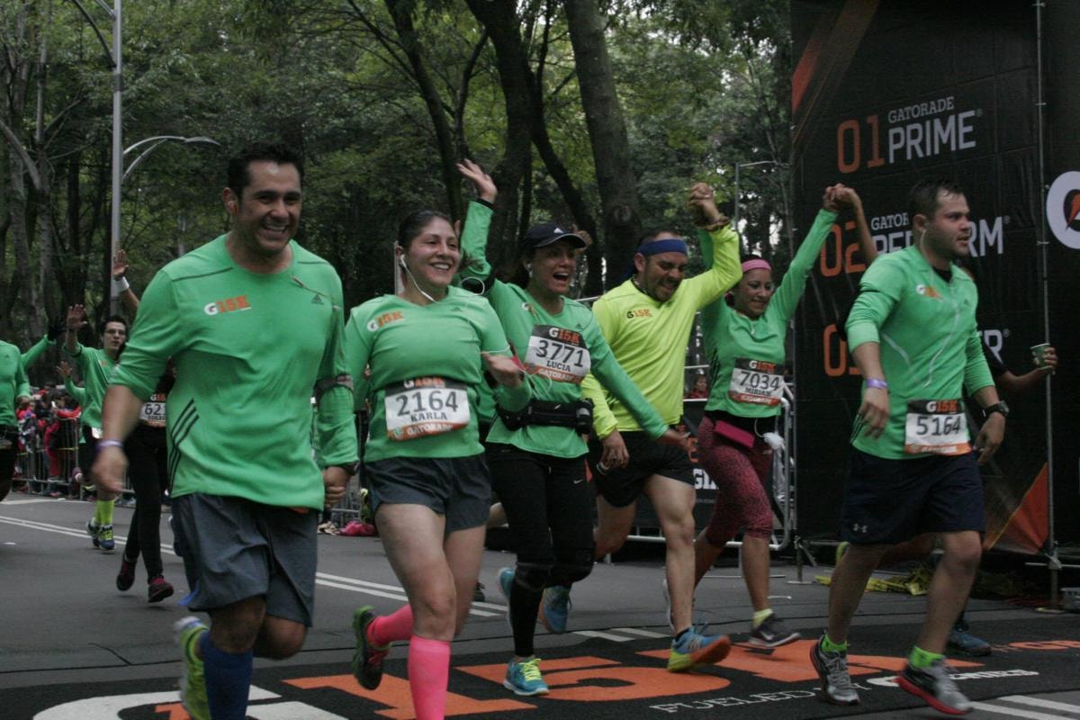 Equipo de corredores con playeras verdes del G15K cruzando la meta