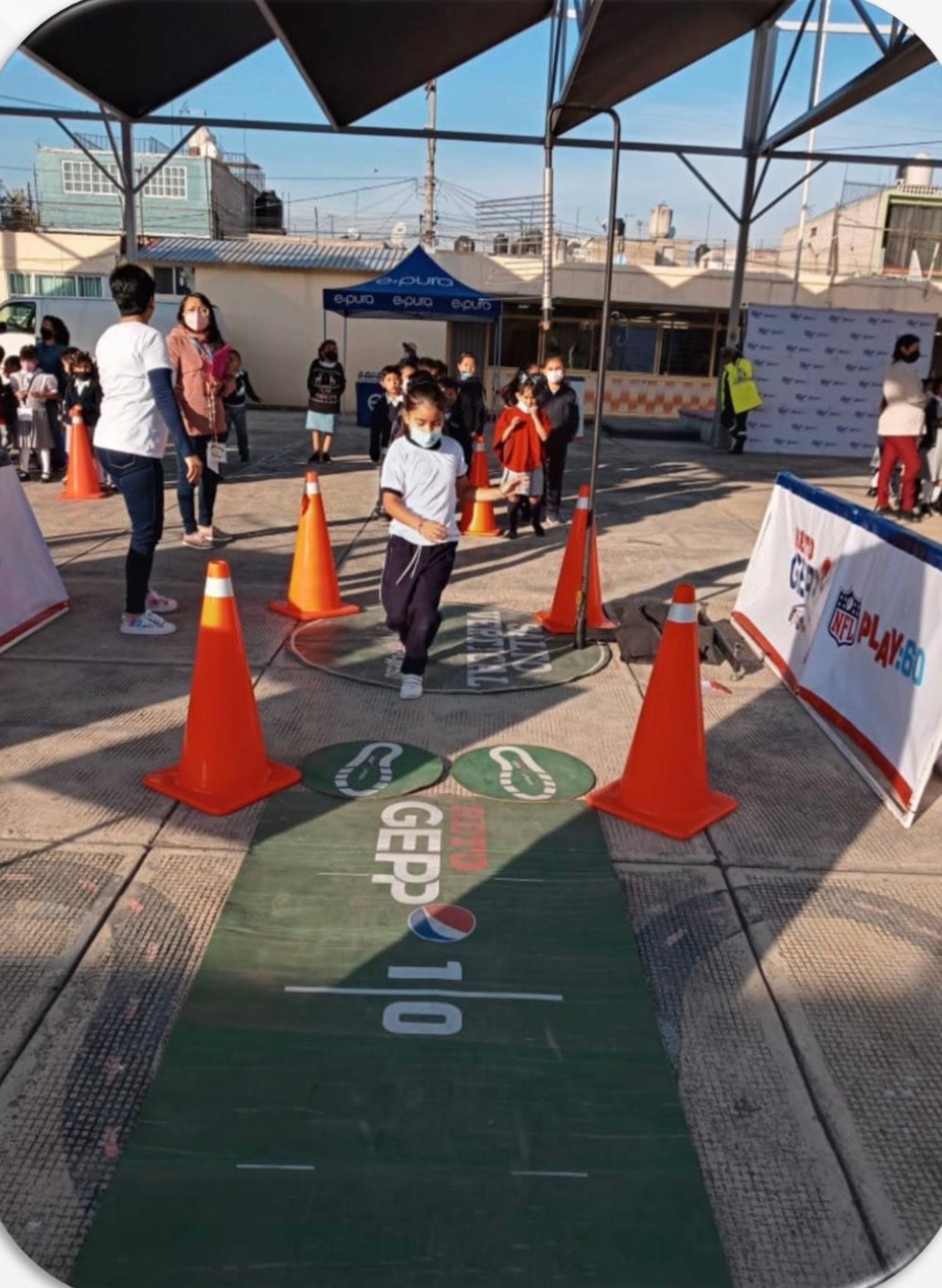 Reto Gepp — niña corriendo en pista NFL Play 60 con conos naranjas