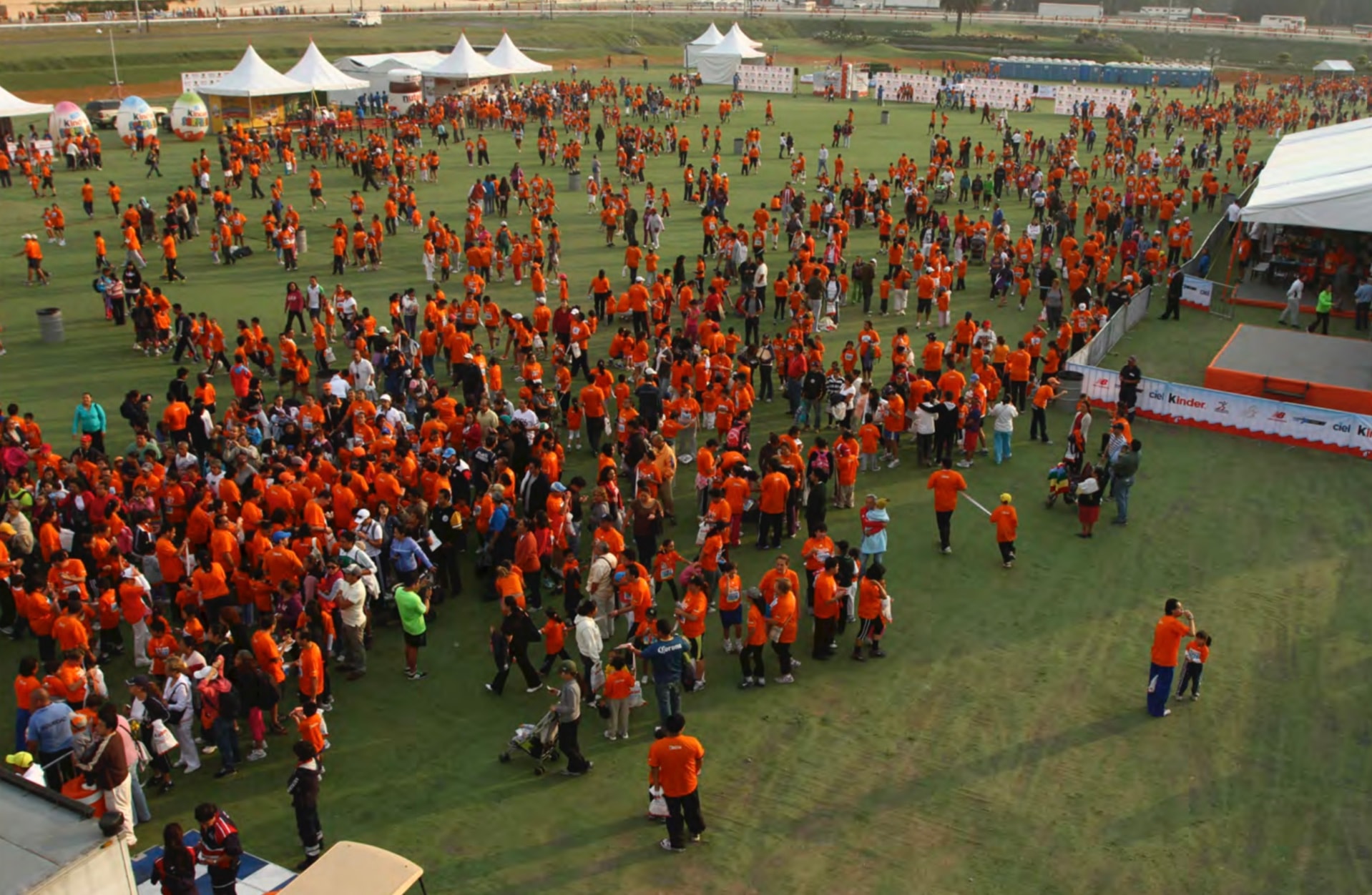Kinder Run — multitud naranja en el campo