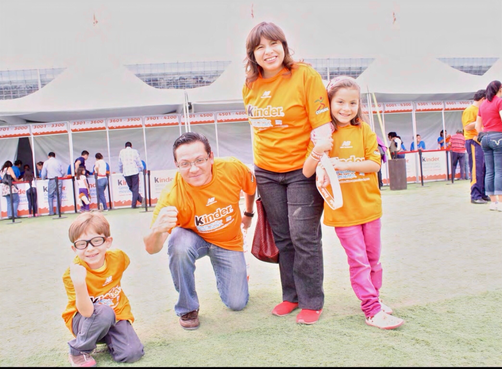 Kinder Run — familia completa en camisetas naranjas Kinder