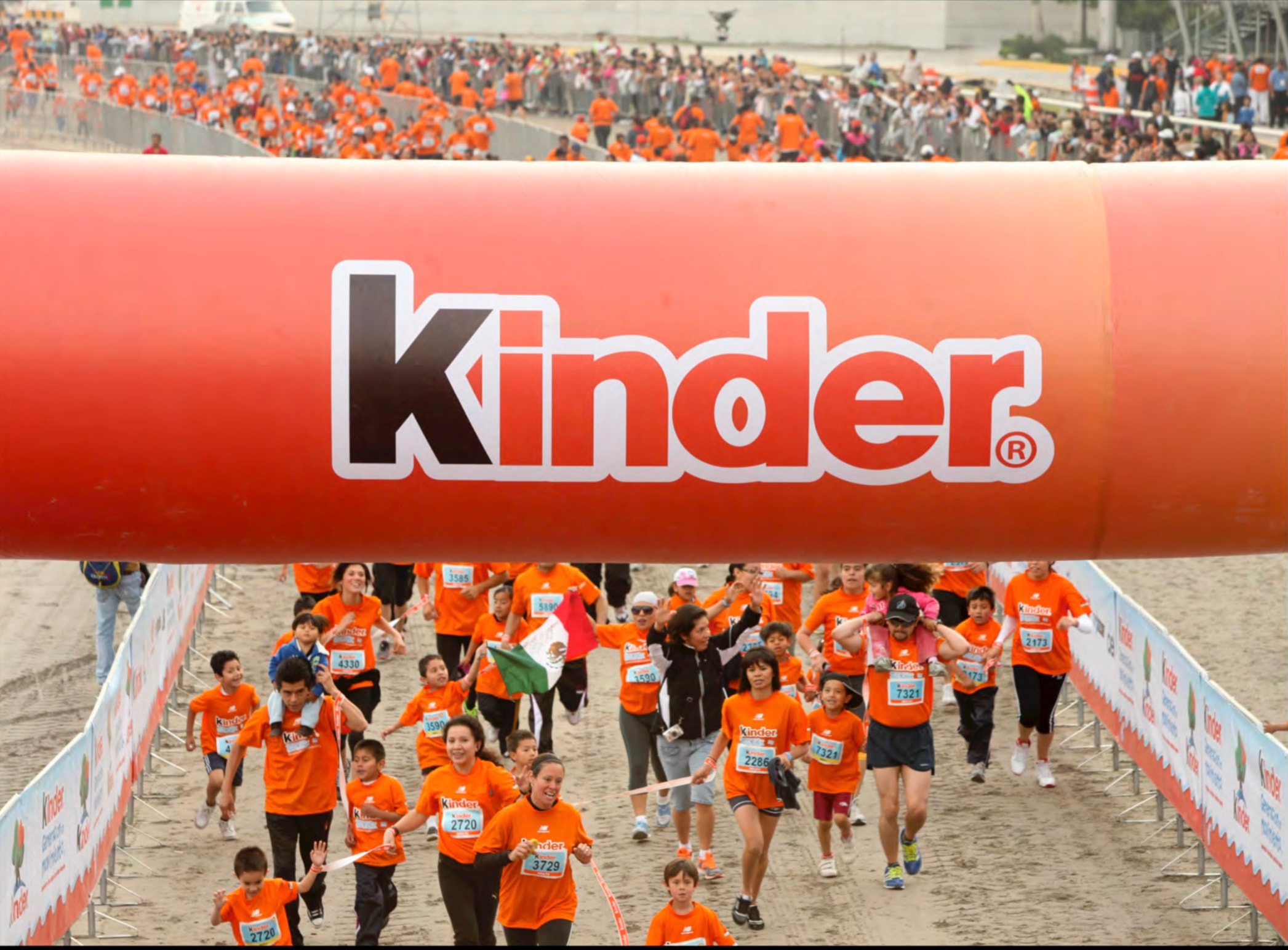 Kinder Run — padre e hija celebrando con los brazos en alto