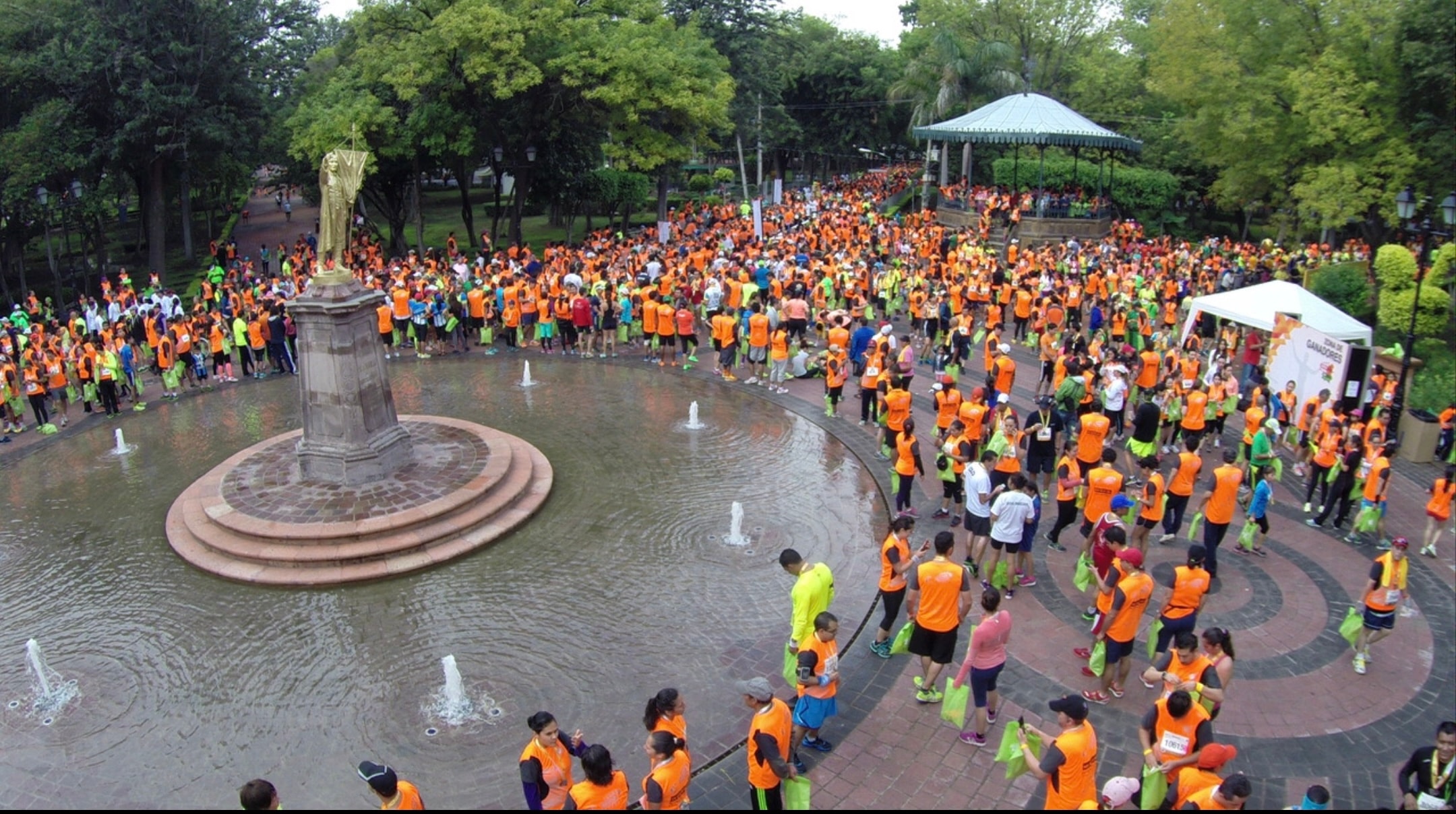 Querétaro Marathon — participantes en camisetas naranjas en la plaza